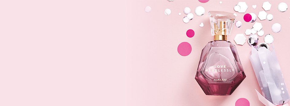 Der Flakon des Love Fearlessly® Eau de Parfum von Mary Kay liegt zusammen mit pinkem und weißem Konfetti auf einem rosa Hintergrund.