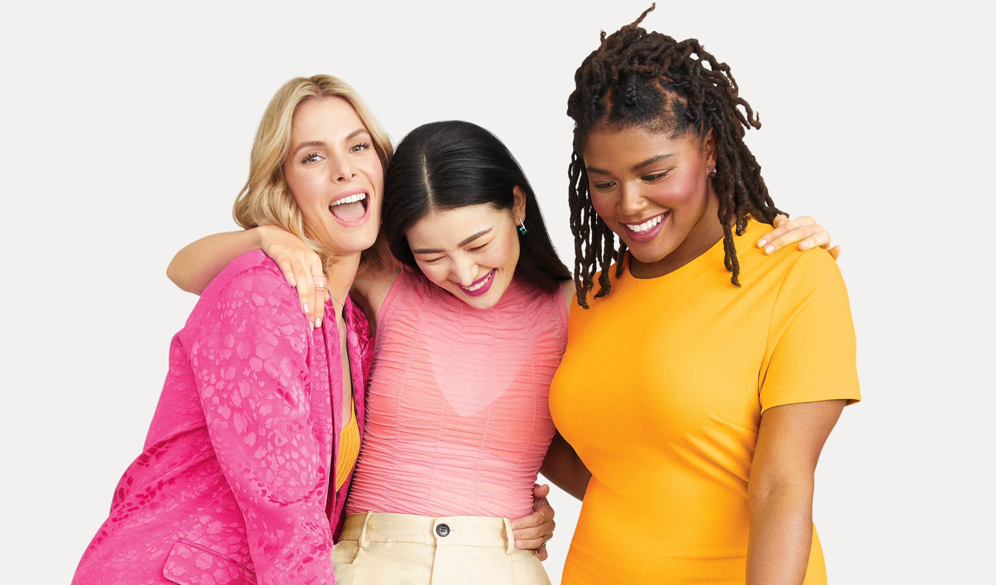 Drei Frauen mit unterschiedlichen Haut- und Haarfarben, in Pink, rosa und Orange gekleidet, umarmen sich und lachen. Um sie herum Dreiecke in Rosa, Pink, Orange.