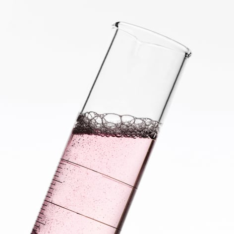 Nahaufnahme eines Reagenzglases, das eine rosa Flüssigkeit enthält