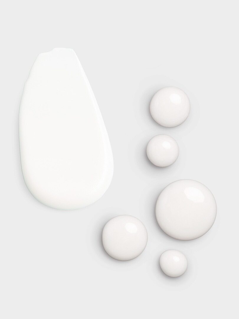 Mehrere Tropfen der weißen Calm + Restore Facial Milk aus dem Clinical Solutions Set mit Retinol Serum