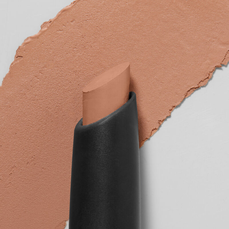 Mary Kay Matte Eye Shadow Stick in Celestial Nude schrage Spitze im Vordergrund Produktprobe im Hintergrund