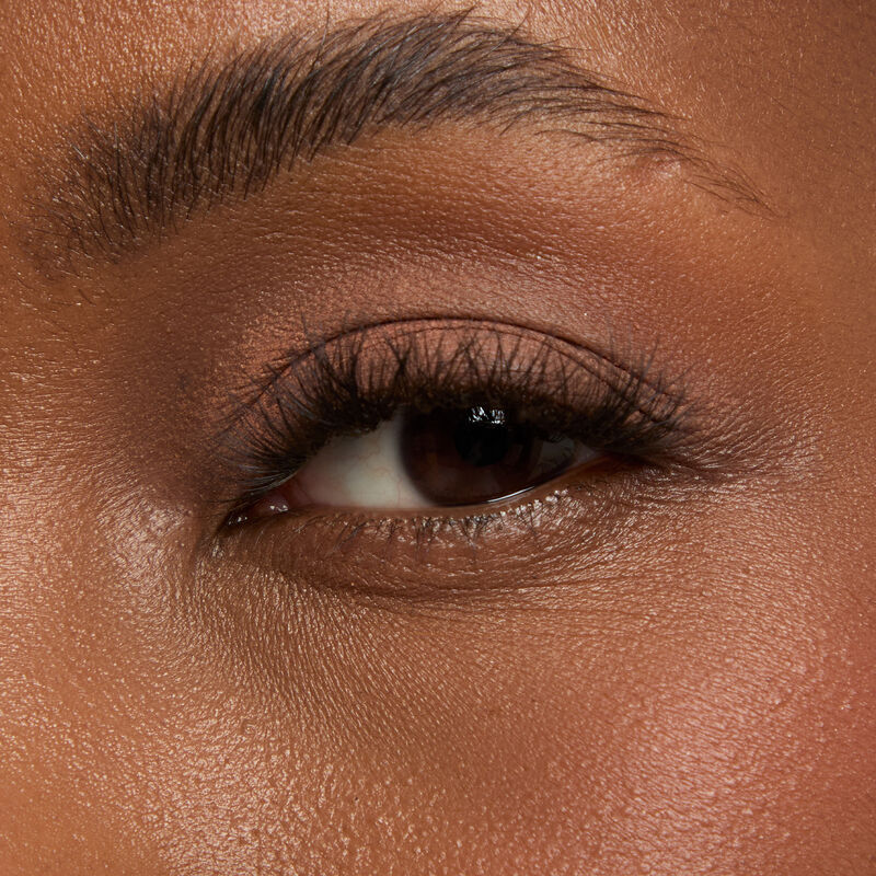 Gro&szlig;aufnahme eines mit Mary Kay Matte Eye Shadow Stick in Celestial Nude geschminkten Auges mit dunklem Hautton