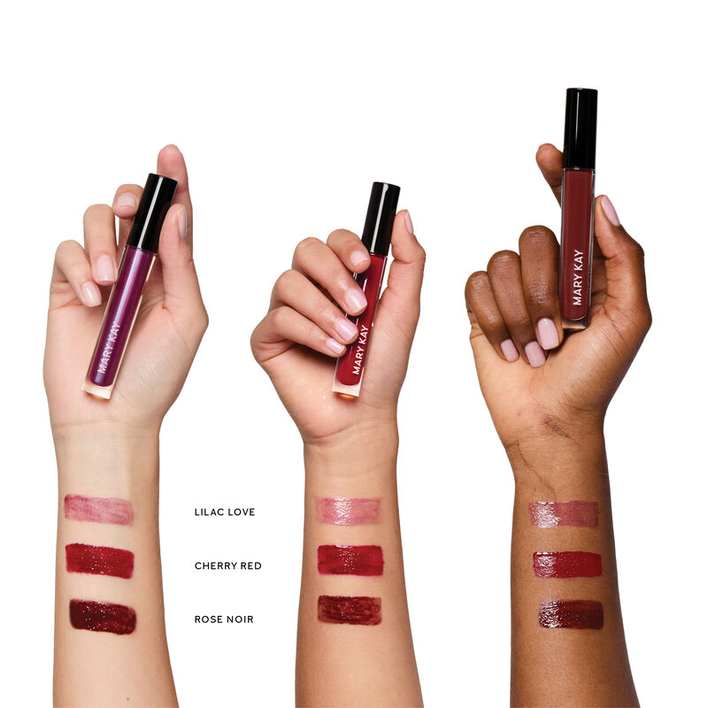 Swipes of Lilac Love, Cherry Red and Rose Noir lip gloss on wrists of light, medium and deep skin tones.