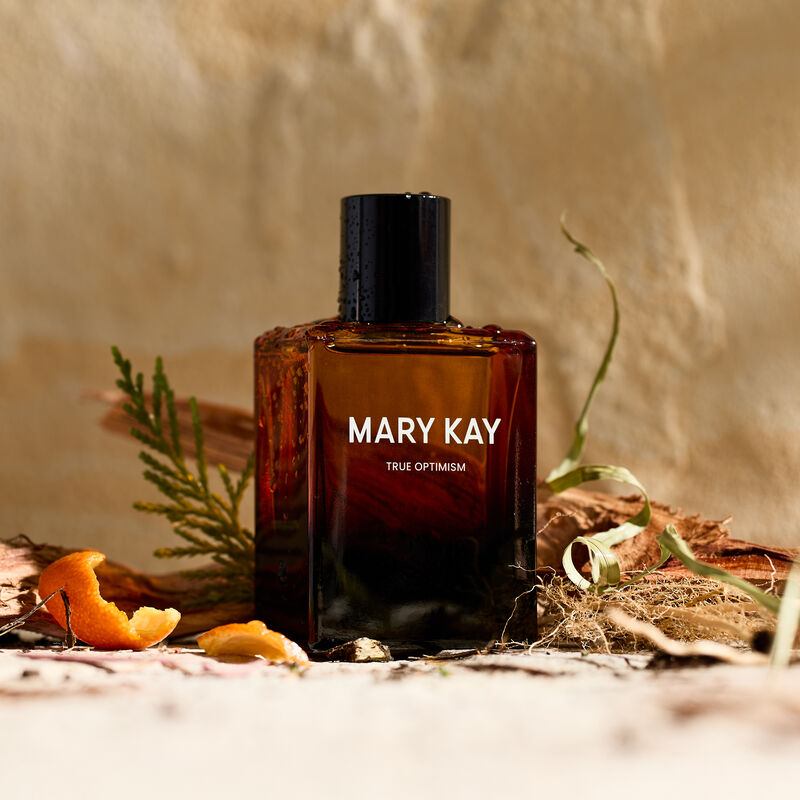 Mary Kay True Optimism Eau de Parfum umgeben von DuftnotenInhaltsstoffen vor SteinHintergrund