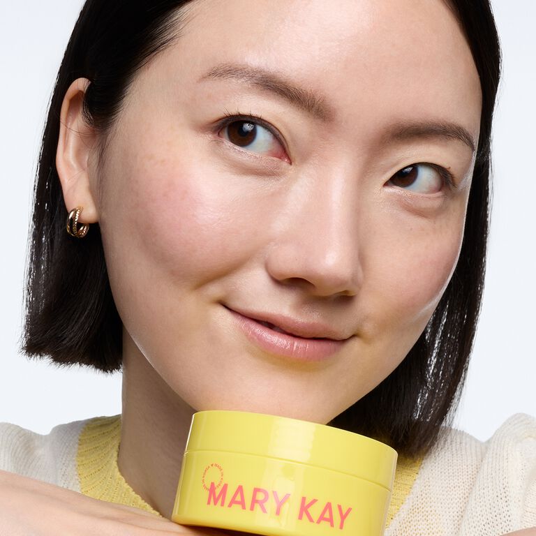 Eine Frau h&auml;lt einen gelben Tiegel der Mary Kay&reg; Snail Gel Face Patches