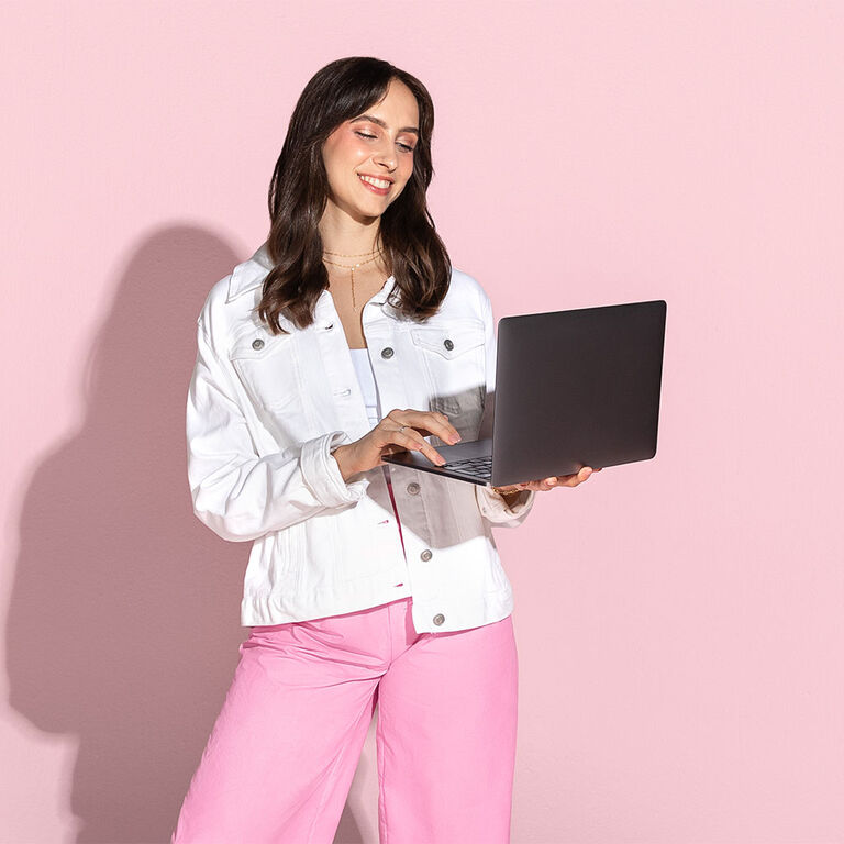 Eine Frau h&auml;lt einen Laptop in der Hand, auf dem sie einen Mary Kay Online Katalog ansieht.