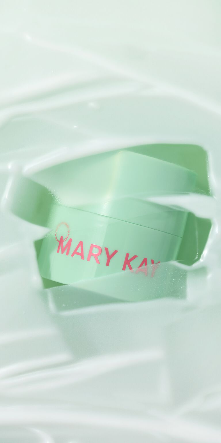 Mintgr&uuml;ner Tiegel des Mary Kay&reg; Melt-In Cleansing Balm, umgeben von cremiger Balm-Textur