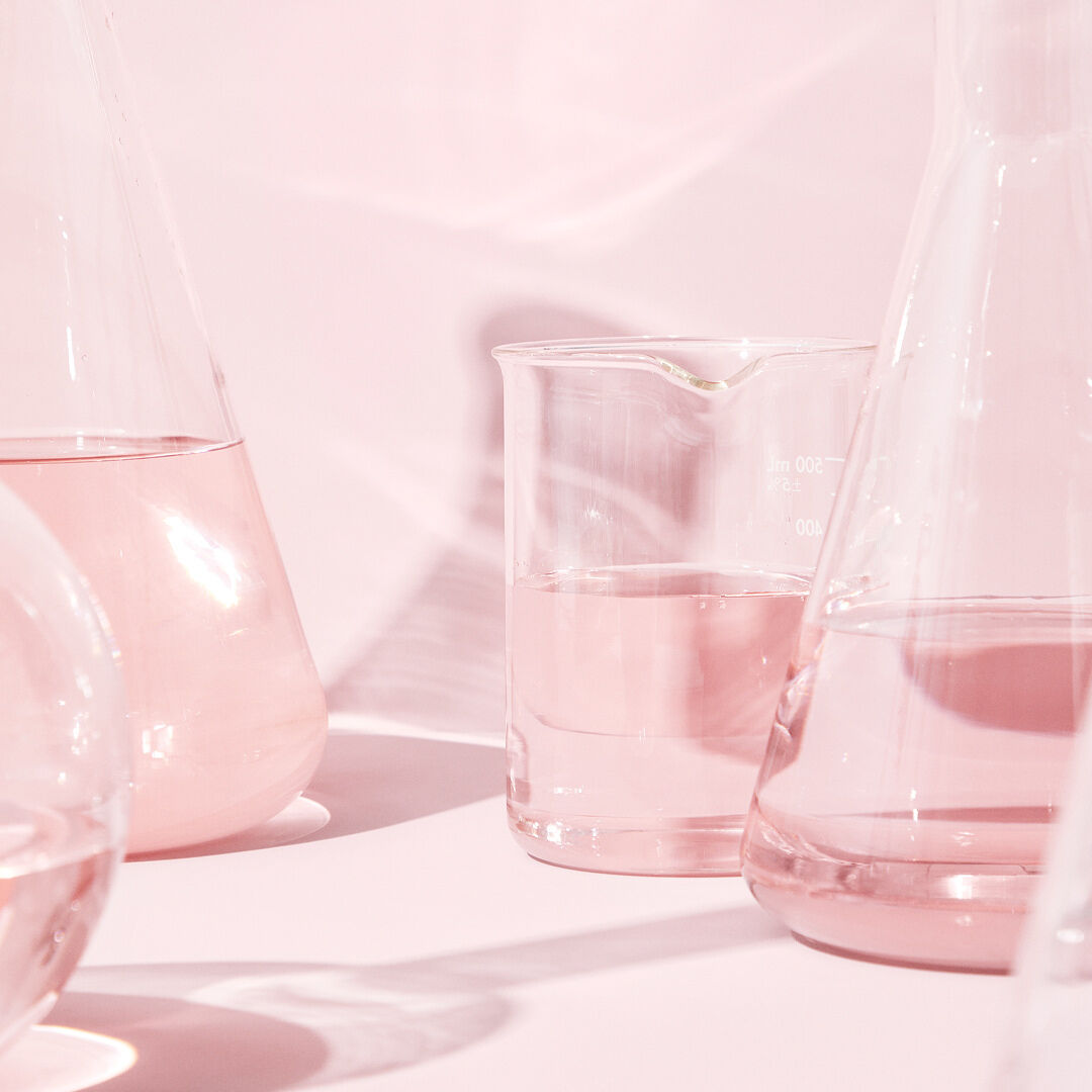 Mehrere Reagenzgl&auml;ser mit rosa Fl&uuml;ssigkeit, die Feuchtigkeit spendet