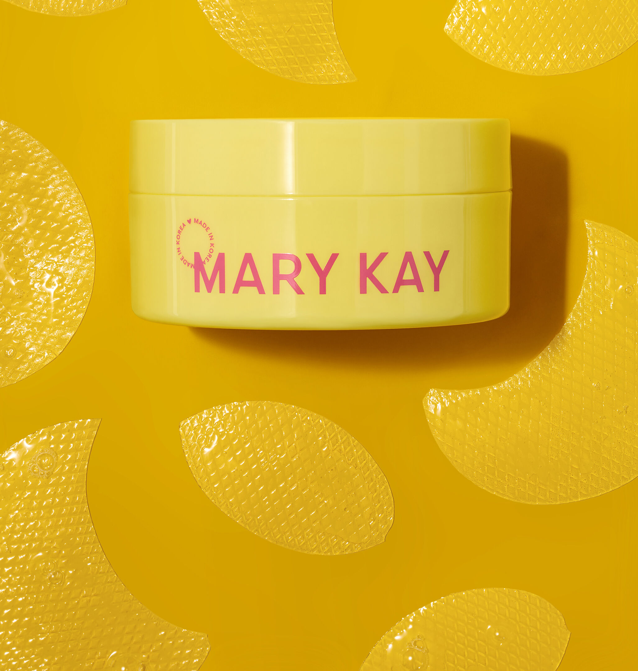 Gelber Tiegel der Mary Kay&reg; Snail Gel Face Patches, umgeben von gelben Gesichtspatches