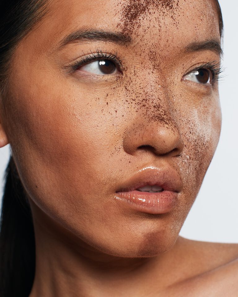 Im Gesicht einer Frau ist eine H&auml;lfte mit dem Underpainting Make-up Trend geschminkt.