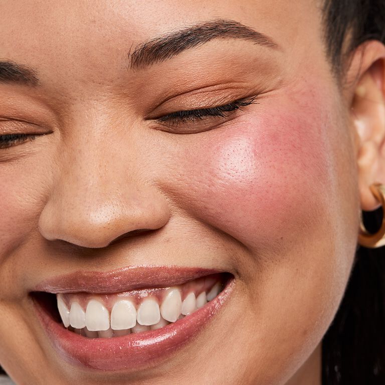 Nahaufnahme einer lachenden Frau, die auf den Wangen den roten Blush tr&auml;gt (Blush Stick in der Shade "Spark Change" von Mary Kay)