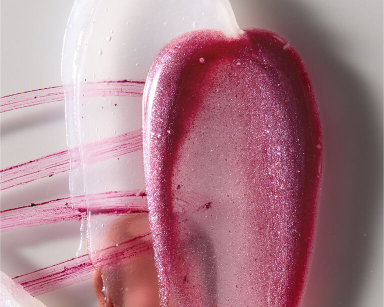 Kleckse von Produkten, die beim Glass Lips Make-up Trend zum Einsatz kommen: Lip Scrub und Lip Balm, Lipliner und Lipgloss in unterschiedlichen Nuancen