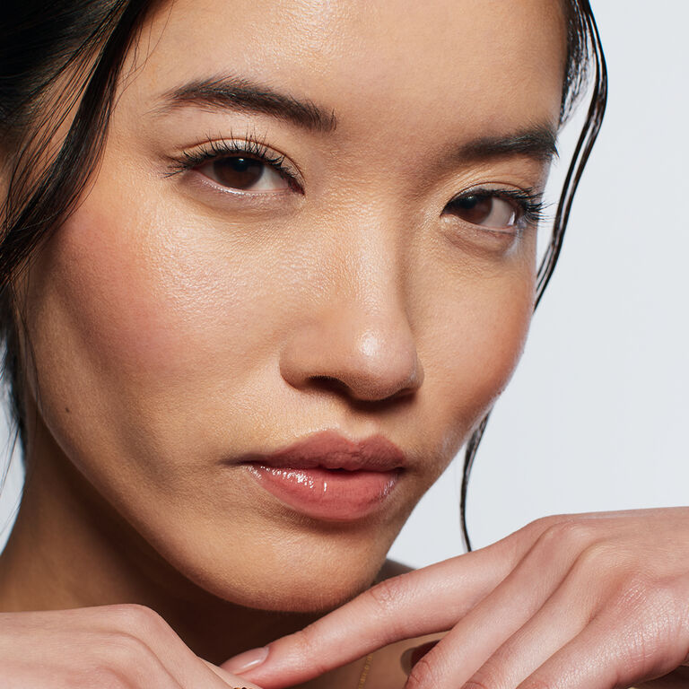 In einer Gesichtsh&auml;lfte tr&auml;gt eine Frau den Underpainting Make-up Trend.