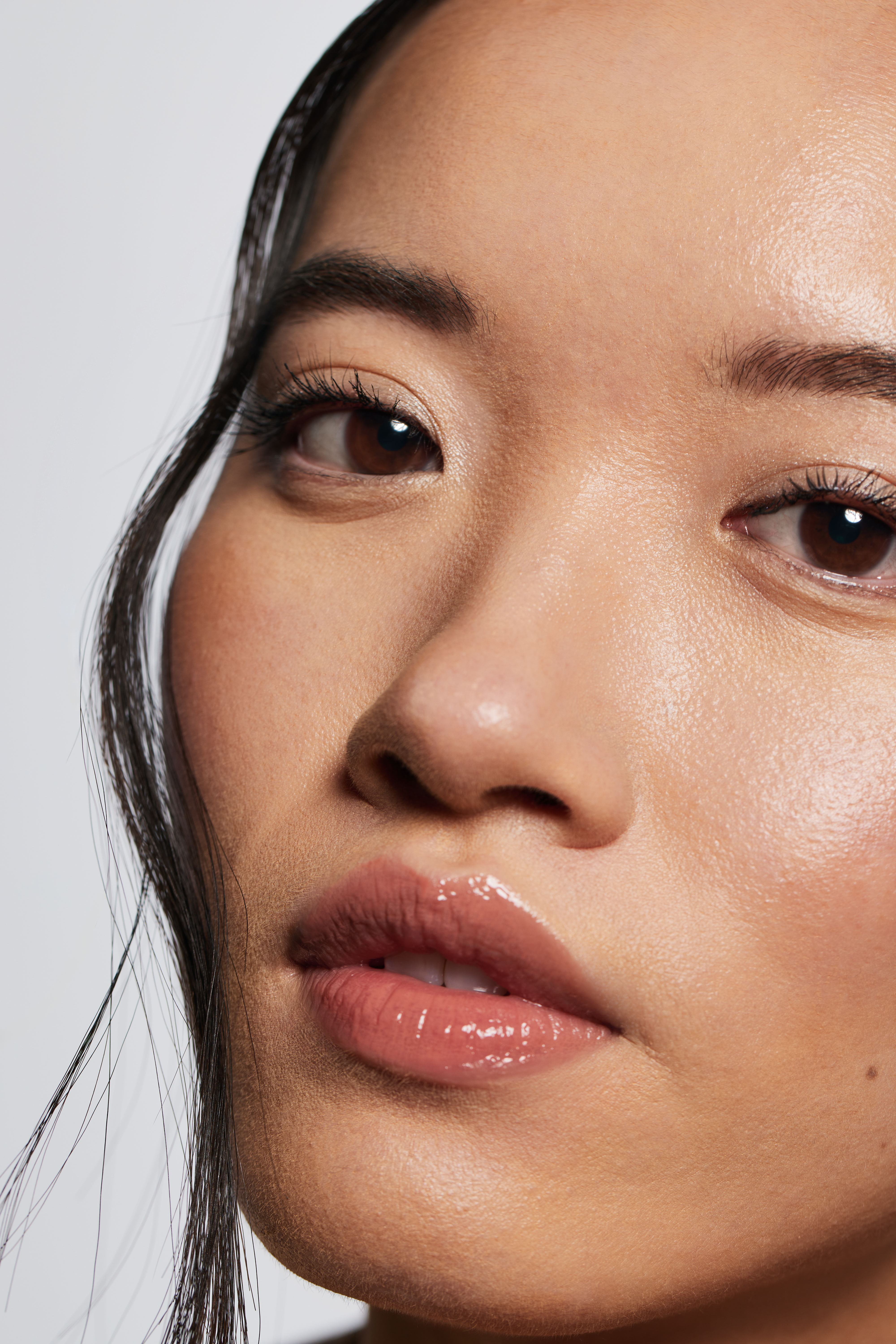 Detailaufnahme eines Gesichts mit ebenmäßigem Teint, inspiriert vom Underpainting-Make-up-Trend.