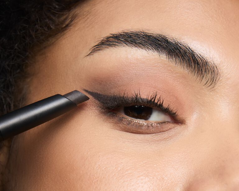 Nahaufnahme einer Frau, die den Mary Kay Matte Eye Shadow Stick mit der abgeschr&auml;gten Spitze entlang des Wimpernkranzes als Eyeliner auftr&auml;gt
