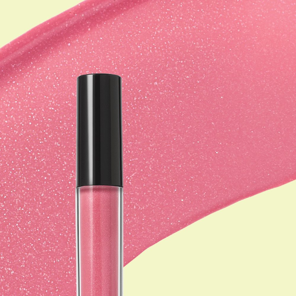 Eine Tube Mary Kay Unlimited Lip Gloss. Im Hintergrund ein Smudge von pinkem Lipgloss.