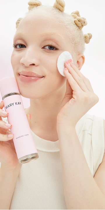 Eine junge Frau mit strahlender, gepflegter Haut tr&auml;gt mit einem Wattepad Mary Kay Balancing Toner auf ihrem Gesicht auf