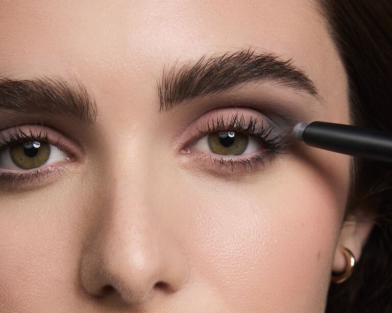 Nahaufnahme einer Frau, die einen dunklen Mary Kay Matte Eyshadow Stick auftr&auml;gt