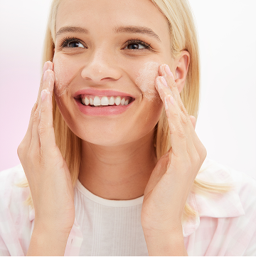 Eine junge Frau reinigt ihr Gesicht mit beiden H&auml;nden mit dem Mary Kay Cleanser (als Mattifying oder Hydrating Cleanser erh&auml;ltlich)