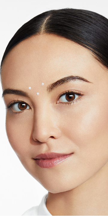 Eine Frau hat an f&uuml;nf Punkten auf der Stirn den TimeWise Repair Volu-Firm Deep Wrinkle Filler von Mary Kay aufgetragen