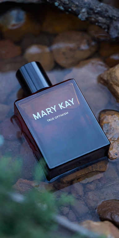 Mary Kay True Optimism Eau de Parfum Flakon zwischen Steinen in klarem Wasser